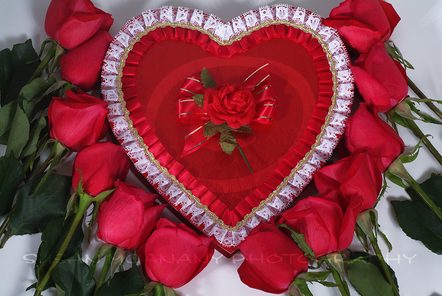 image of heart shaped candy box surrounded with red roses